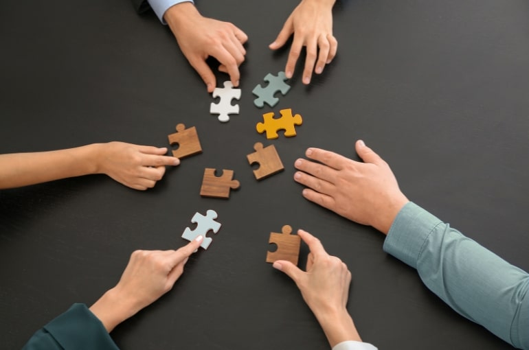 Personnes qui cherchent à assembler un casse-tête. Article de blogue - Collaboration ou collabillusion ? Découvrez les leviers d’une collaboration authentique | Marie-Andrée Roy, Services conseil et Design Thinking